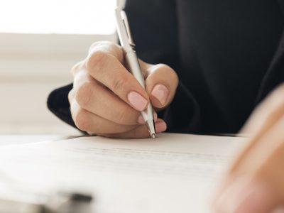 close-up-person-signing-certificate